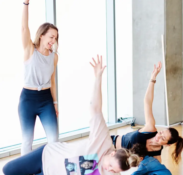 Emma teaching a mat class, with a baby and a toddler on the mats beside their mums